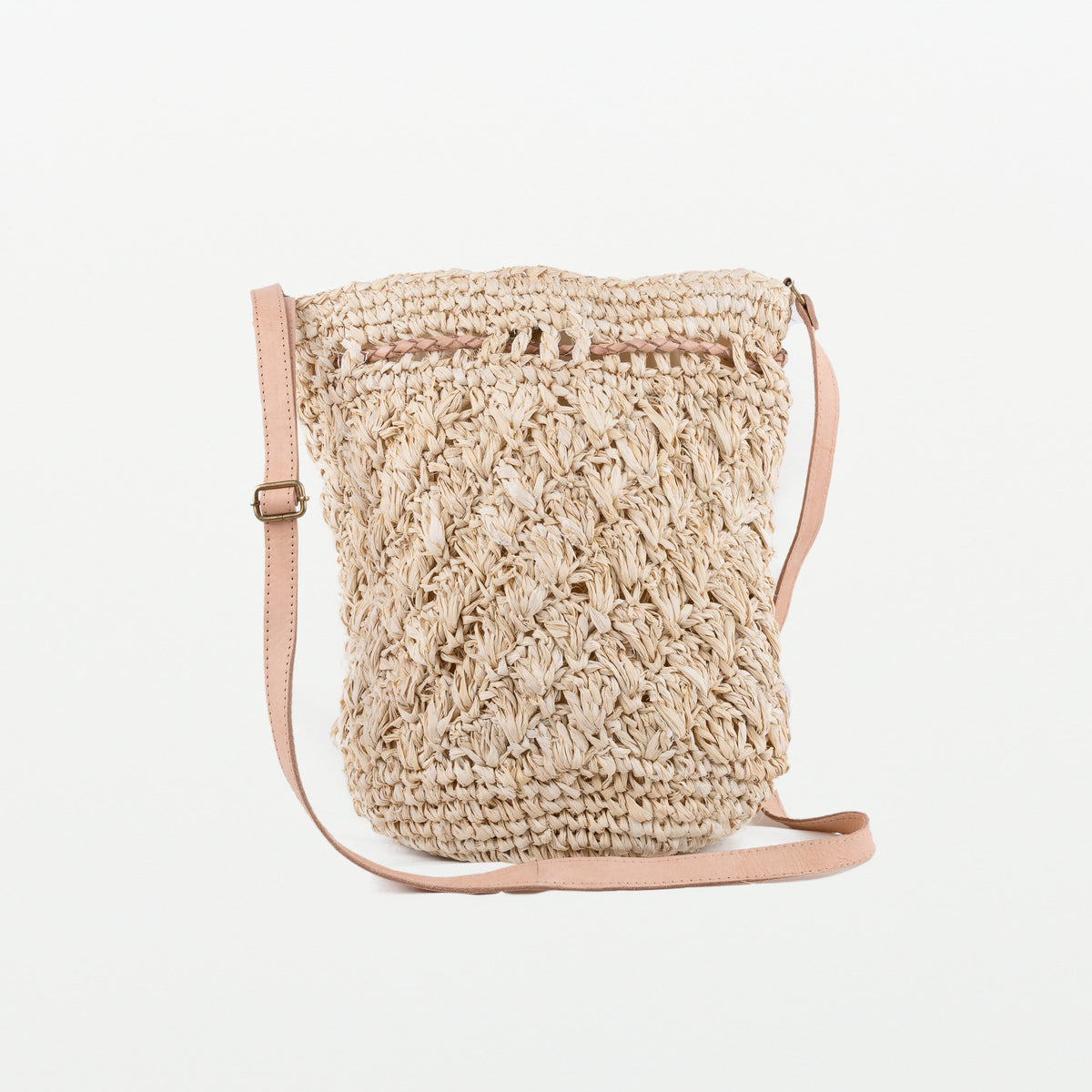 Raffia light handbag with textured pattern detail. Adjustable leather strap and leather pull-ties. Magnetic clasp closing. Fully lined with inside pocket.