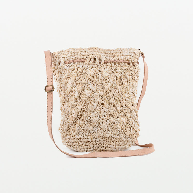 Raffia light handbag with textured pattern detail. Adjustable leather strap and leather pull-ties. Magnetic clasp closing. Fully lined with inside pocket.