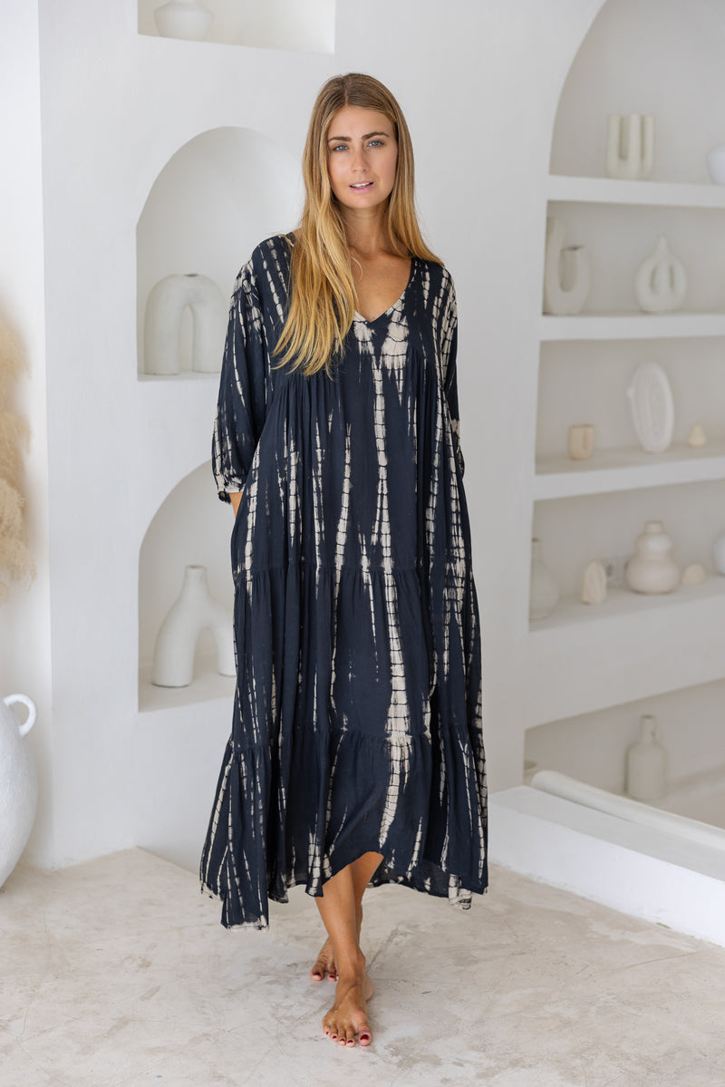 womens mid length tie dye tiered tunic dress in black featuring a v neckline, long sleeves and side pockets