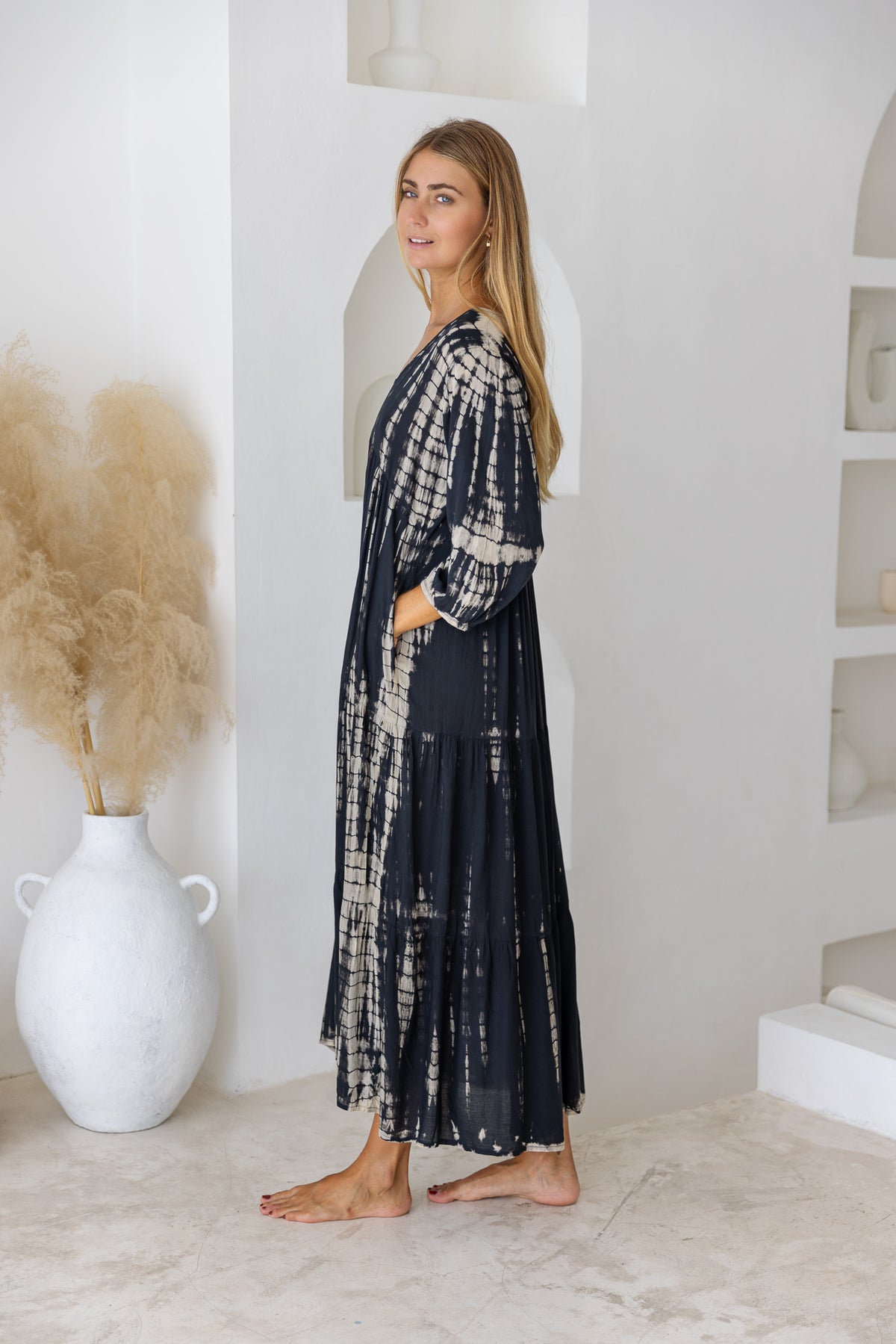 womens mid length tie dye tiered tunic dress in black featuring a v neckline, long sleeves and side pockets