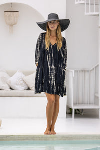 womens short length tie dye tiered tunic dress in black featuring a v neckline, long sleeves and side pockets