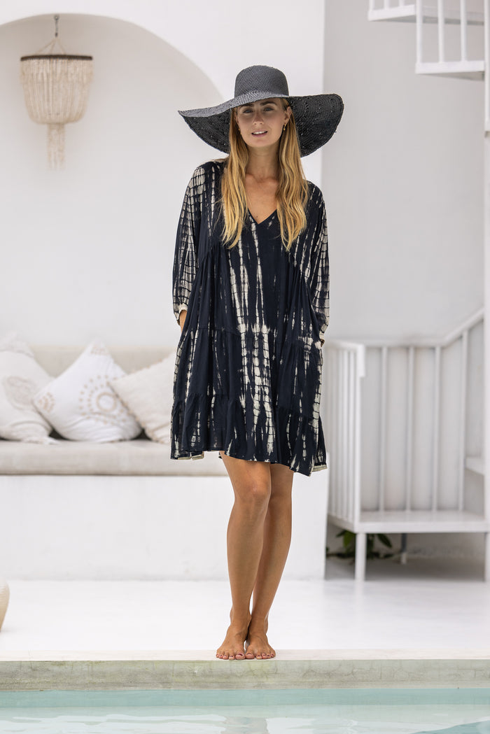 womens short length tie dye tiered tunic dress in black featuring a v neckline, long sleeves and side pockets