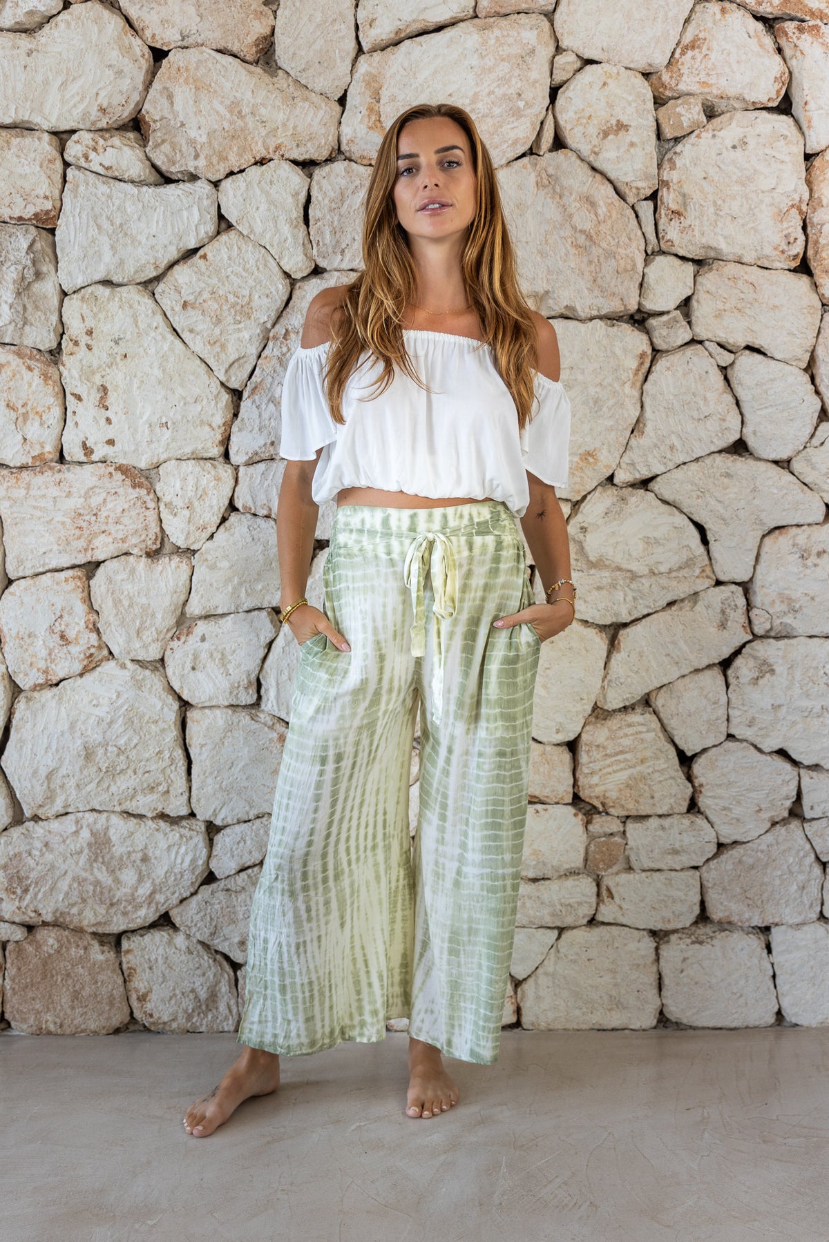 Stylish, super soft wide leg culotte style tie-dye trousers in green featuring an elasticated waist, belt detail and pockets for a flattering and comfortable fit
