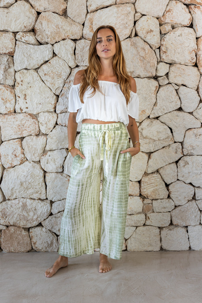 Stylish, super soft wide leg culotte style tie-dye trousers in green featuring an elasticated waist, belt detail and pockets for a flattering and comfortable fit