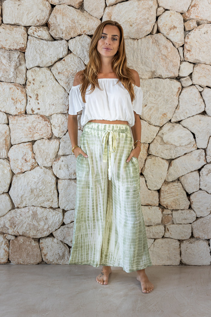 Stylish, super soft wide leg culotte style tie-dye trousers in green featuring an elasticated waist, belt detail and pockets for a flattering and comfortable fit