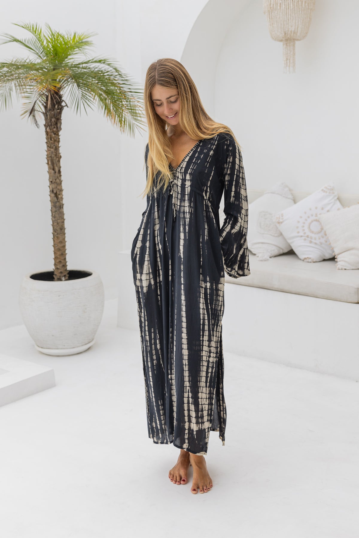 womens full length tie dye summer dress in black featuring a hand beaded v neckline, pull ties under the bust, trumpet sleeves, pockets and side splits