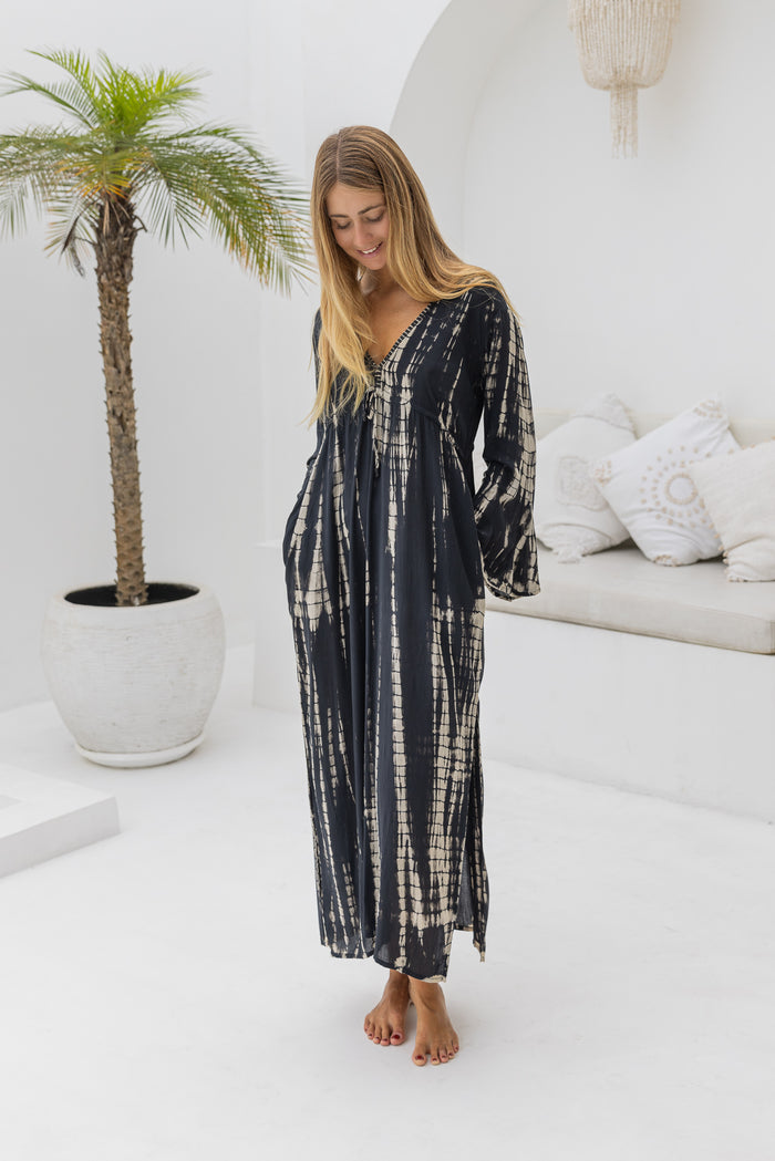womens full length tie dye summer dress in black featuring a hand beaded v neckline, pull ties under the bust, trumpet sleeves, pockets and side splits