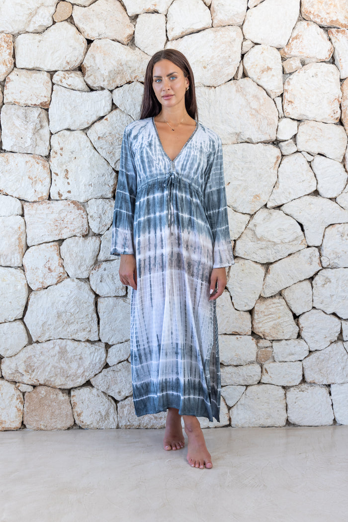 Womens full length tie dye summer dress in light grey featuring a hand beaded v neckline, pull ties under the bust, trumpet sleeves and side splits