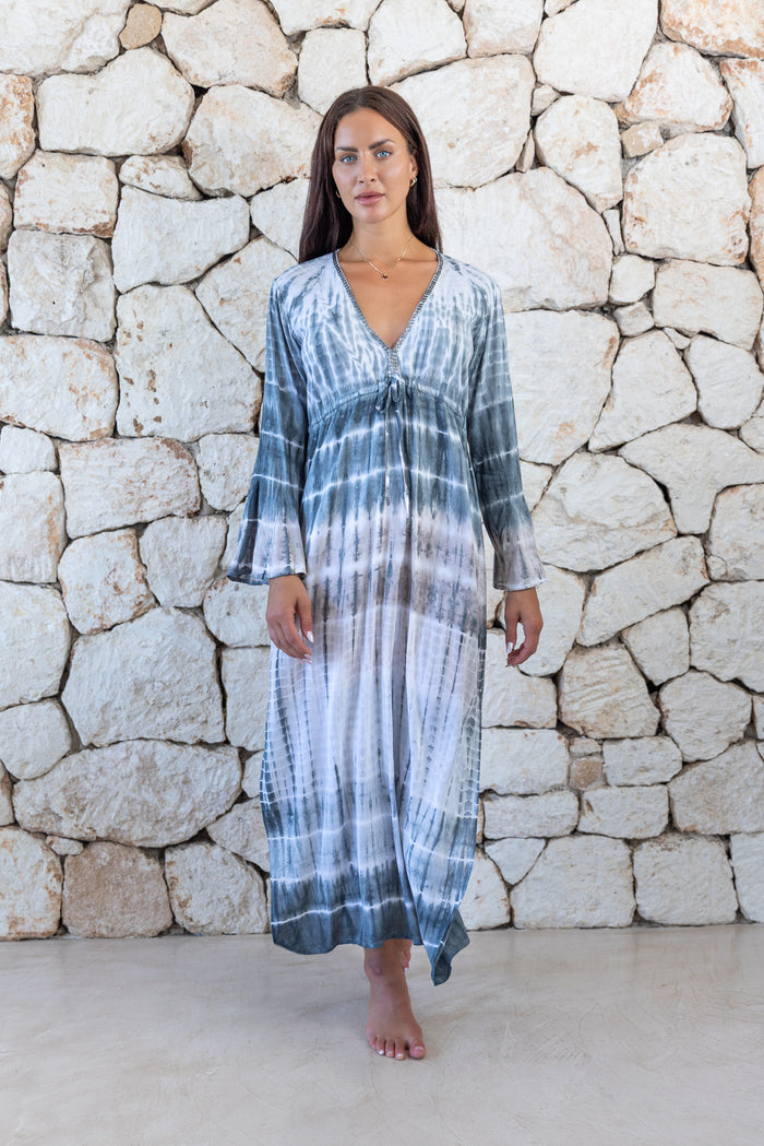 Womens full length tie dye summer dress in light grey featuring a hand beaded v neckline, pull ties under the bust, trumpet sleeves and side splits