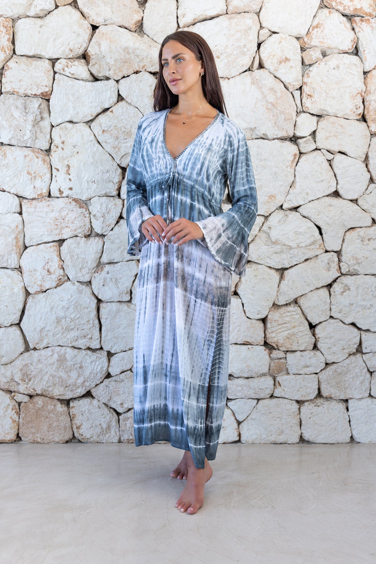 Womens full length tie dye summer dress in light grey featuring a hand beaded v neckline, pull ties under the bust, trumpet sleeves and side splits