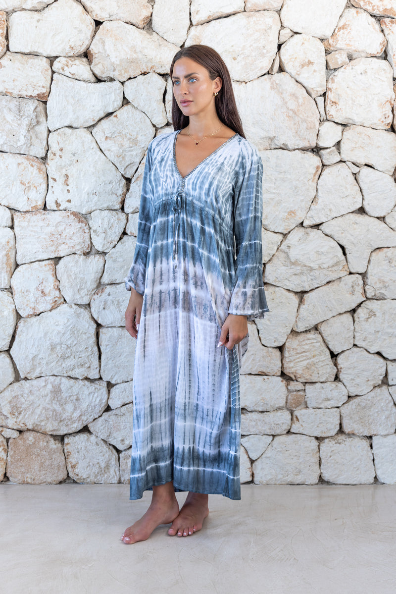 Womens full length tie dye summer dress in light grey featuring a hand beaded v neckline, pull ties under the bust, trumpet sleeves and side splits