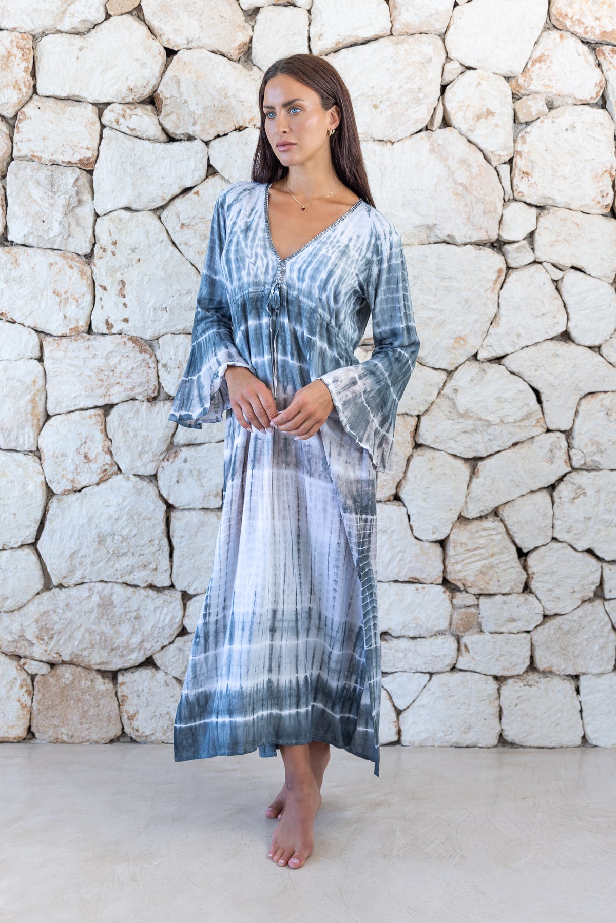 Womens full length tie dye summer dress in light grey featuring a hand beaded v neckline, pull ties under the bust, trumpet sleeves and side splits