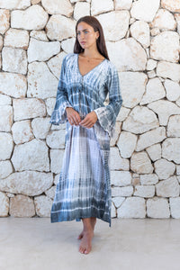Womens full length tie dye summer dress in light grey featuring a hand beaded v neckline, pull ties under the bust, trumpet sleeves and side splits