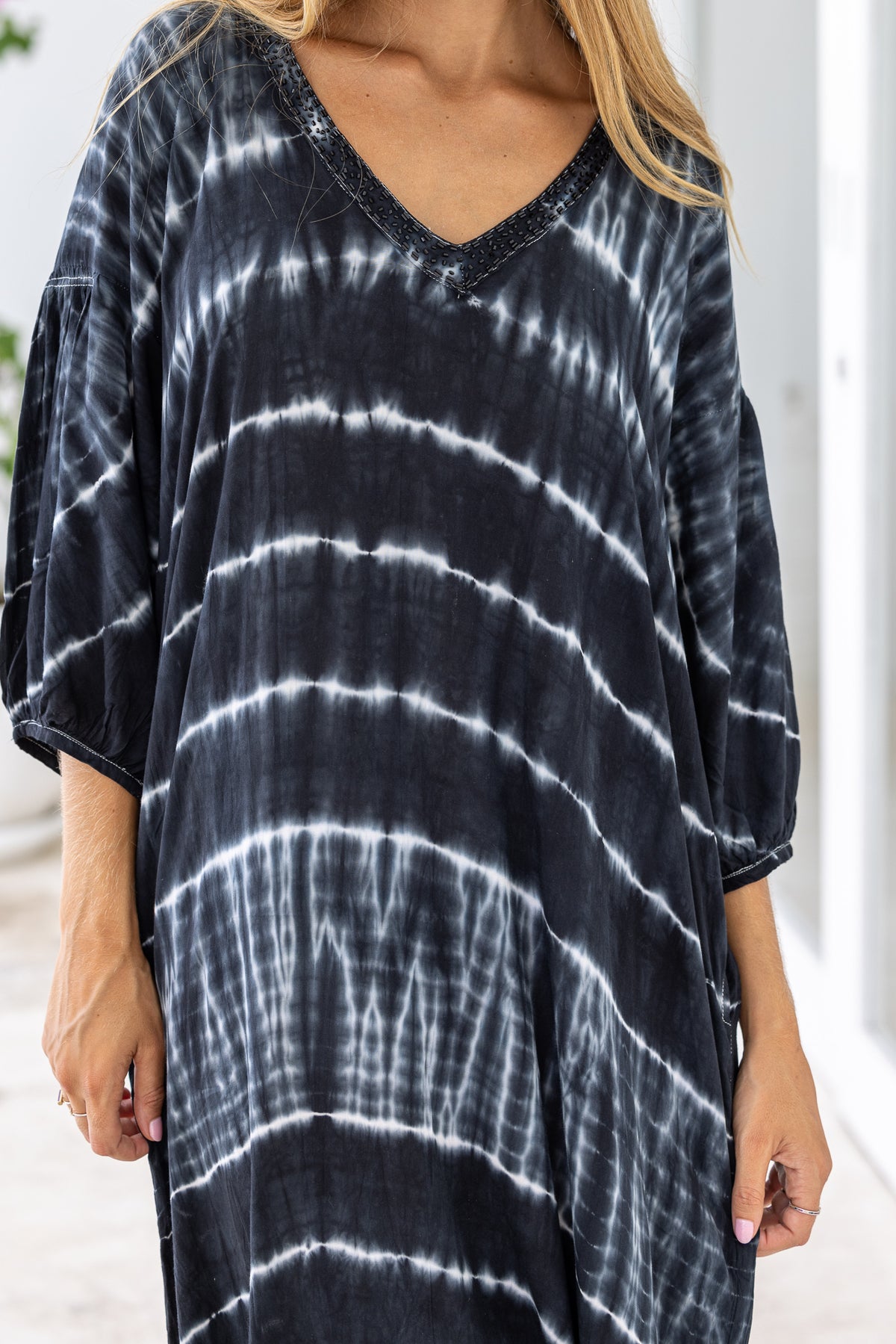 womens mid length oversize tie dye dress in black and cream featuring a hand beaded v neckline, 3/4 length sleeves and pockets