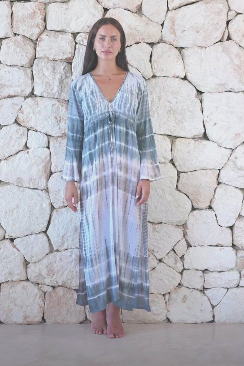 Womens full length tie dye summer dress in light grey featuring a hand beaded v neckline, pull ties under the bust, trumpet sleeves and side splits