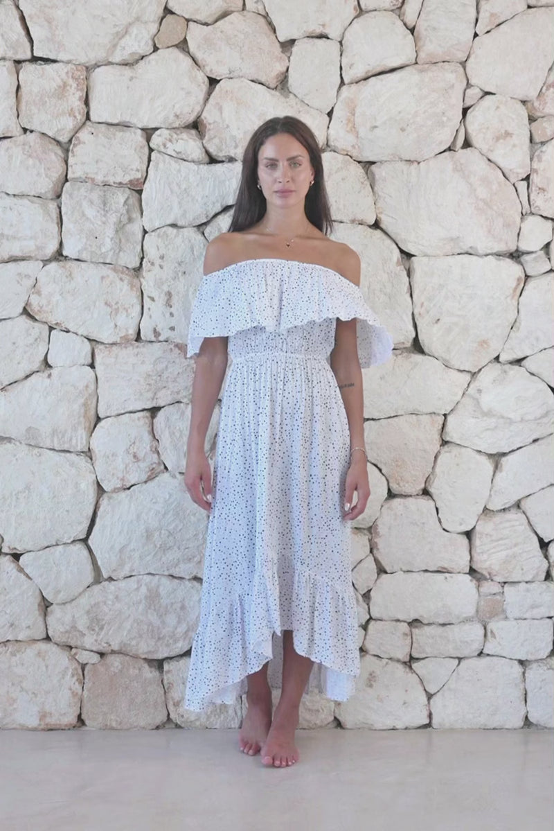Womens elegant long length dress in white polka dot featuring an off the shoulder frill and elasticated waist