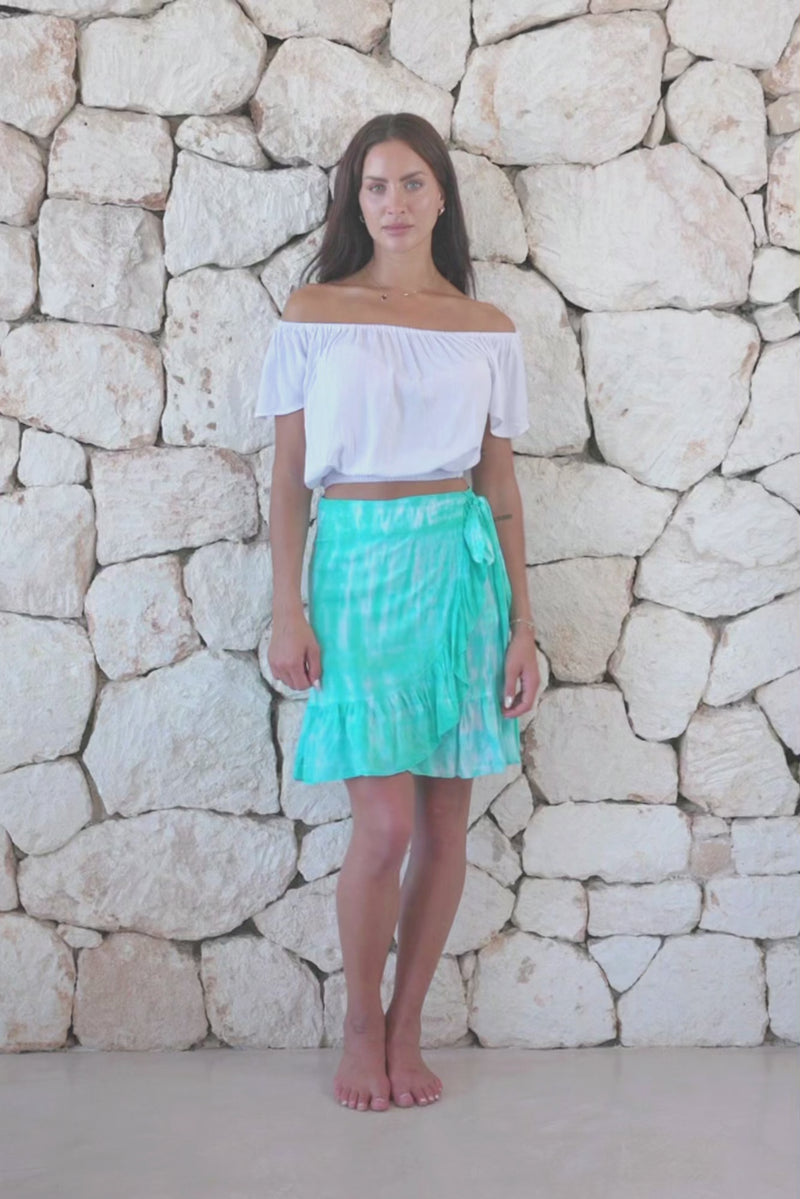 Womens short length tie dye wrap skirt in aqua blue featuring a self tie fastening and ruffle detail