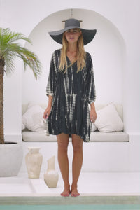 womens mid length tie dye tiered tunic dress in black featuring a v neckline, long sleeves and side pockets
