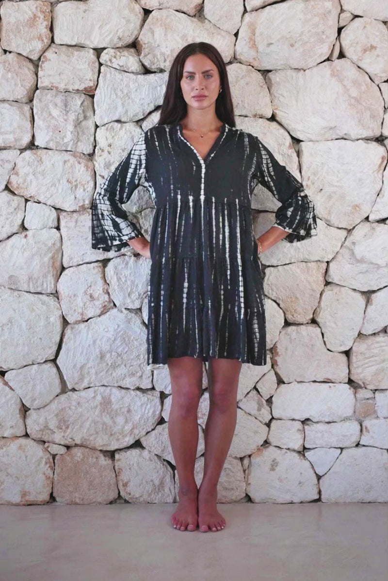 Womens short length tie dye tunic dress in black featuring a tiered silhouette, 3/4 length sleeves and pockets 