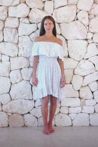 Womens elegant short length dress in white polka dot featuring an off the shoulder frill and elasticated waist