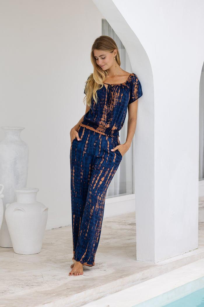 womens tie dye trousers in navy blue and brown  featuring an elasticated waist and pockets 
