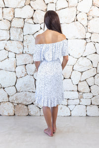 Womens elegant short length dress in white polka dot featuring an off the shoulder frill and elasticated waist
