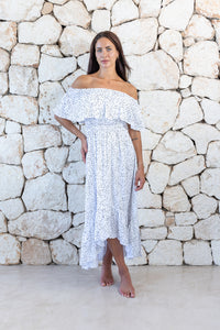 Womens elegant long length dress in white polka dot featuring an off the shoulder frill and elasticated waist