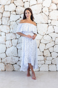 Womens elegant long length dress in white polka dot featuring an off the shoulder frill and elasticated waist